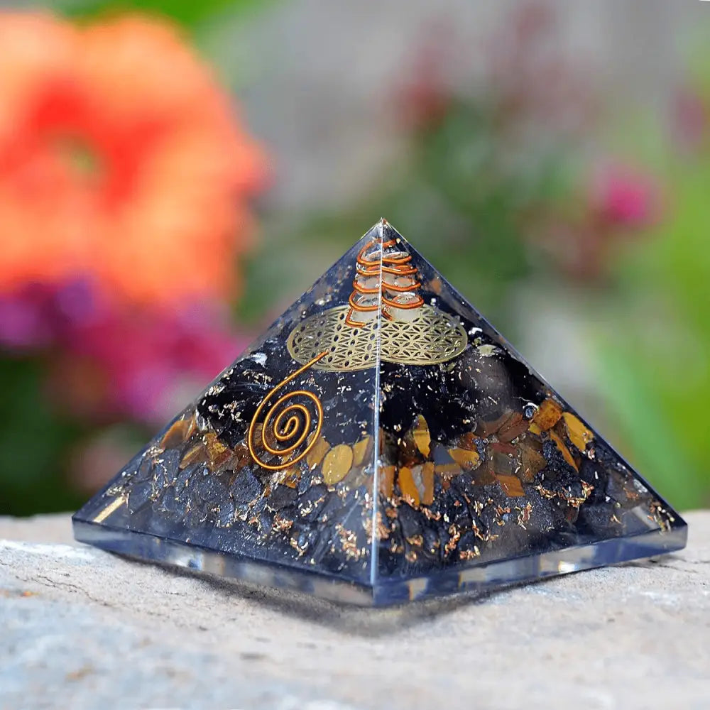 Orgonite pyramid with black tourmaline, tiger eye, and hematite for protection.